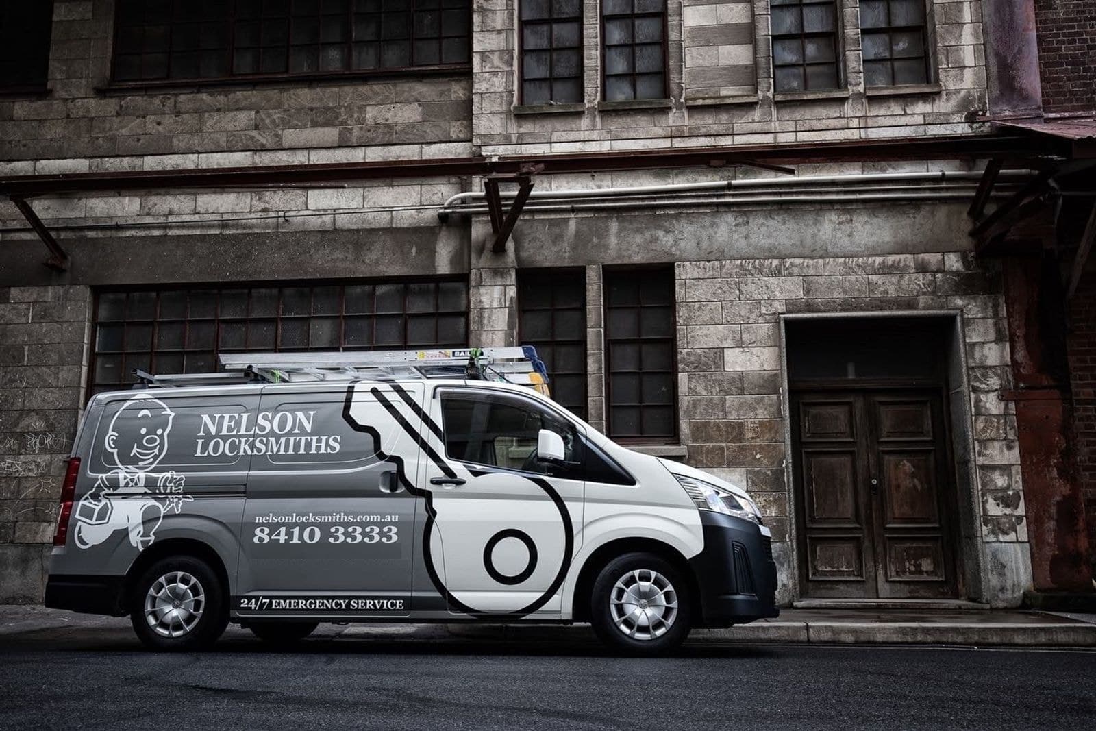 Side view of the Nelson Locksmiths van outside an old stone building