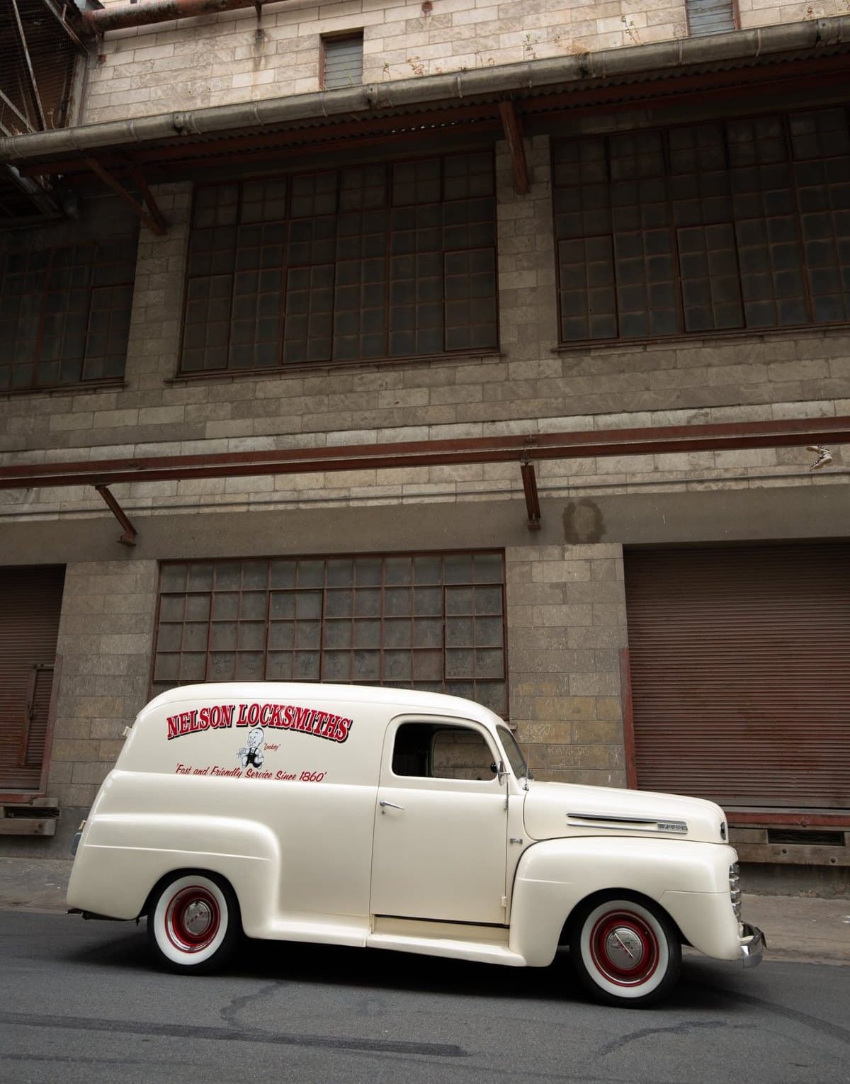 Nelson Locksmiths’ vintage panel van, signwritten “Fast and Friendly Service Since 1860”, outside an old stone warehouse
